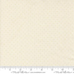 A close-up of a fabric swatch with a repeating small gold dot pattern on a warm cream background, with a measuring ruler along the bottom edge showing scale. The brand name 'Moda Fabrics' is printed on the ruler.