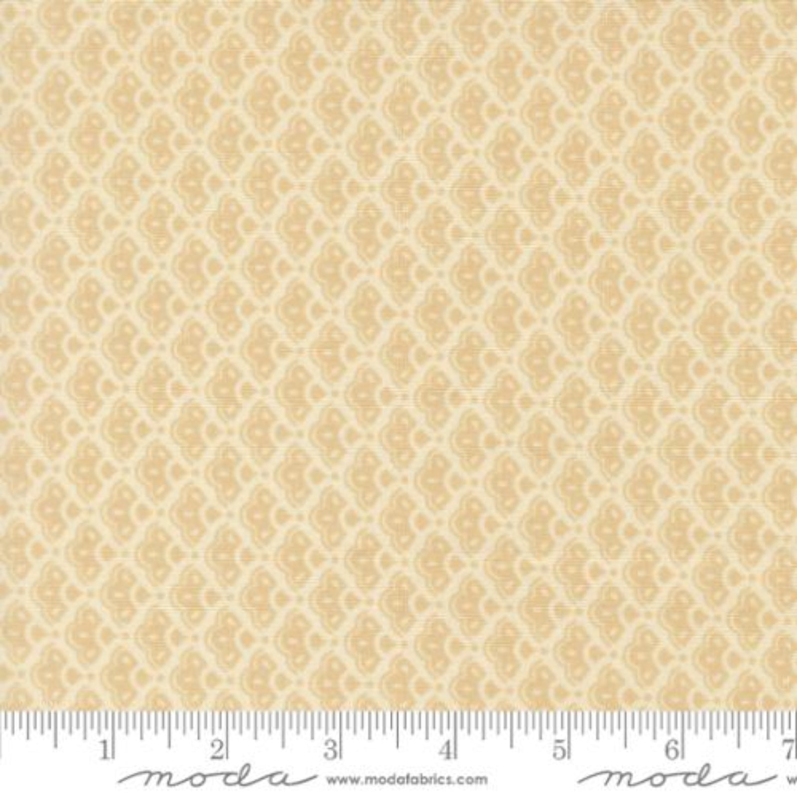 A close-up of a fabric pattern swatch showing a repeating beige and cream damask-style motif, with a ruler along the bottom edge for scale. The Moda Fabrics watermark is visible at the bottom.