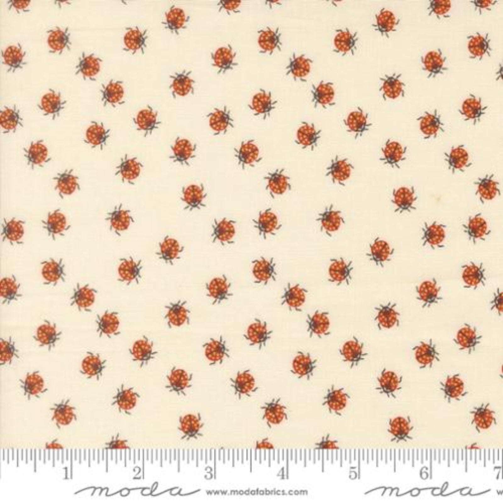 Fabric with small ladybug pattern on a beige background, featuring Moda label.
