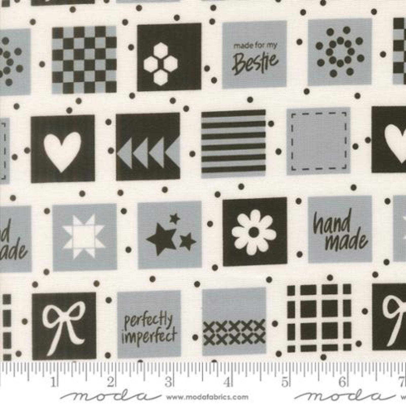 Fabric swatch with black and white patterns and text on a white background, featuring Moda label.