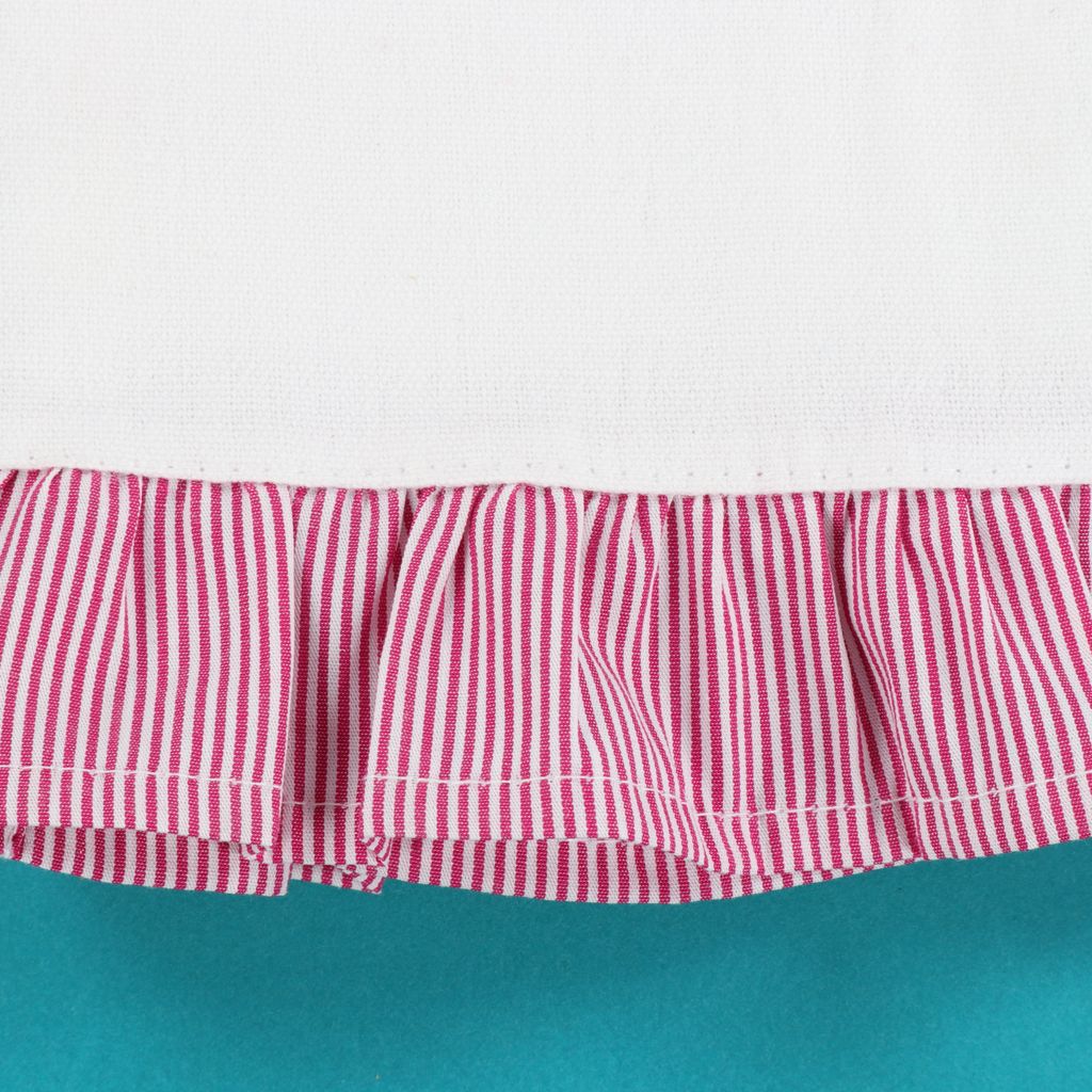 Red and white striped fabric with a ruffled edge on a teal background