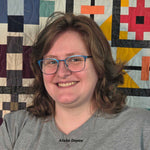 Headshot of instructor Alisha Depew in front of a colorful quilt.