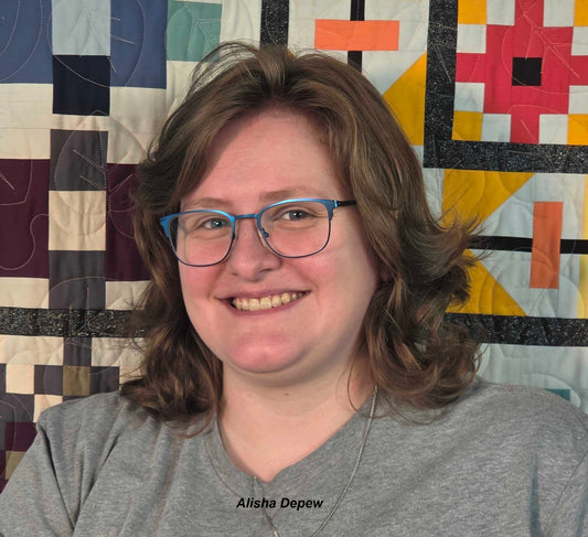 Headshot of instructor Alisha Depew in front of a colorful quilt.