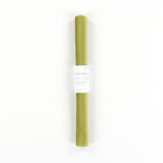 Roll of green velvet with a white label on a white background