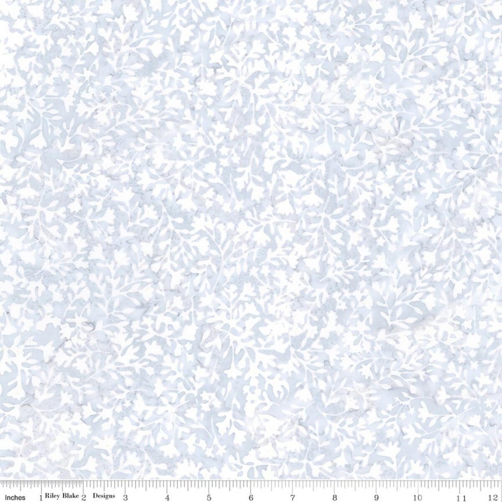 A close-up of a fabric pattern showing a delicate, repeating floral and leaf motif in light blue and white. A ruler at the bottom edge indicates the scale of the print.
