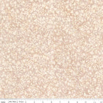 A close-up of a fabric pattern with a delicate beige and cream floral vine design on a light blush pink background, with a ruler at the bottom indicating scale.