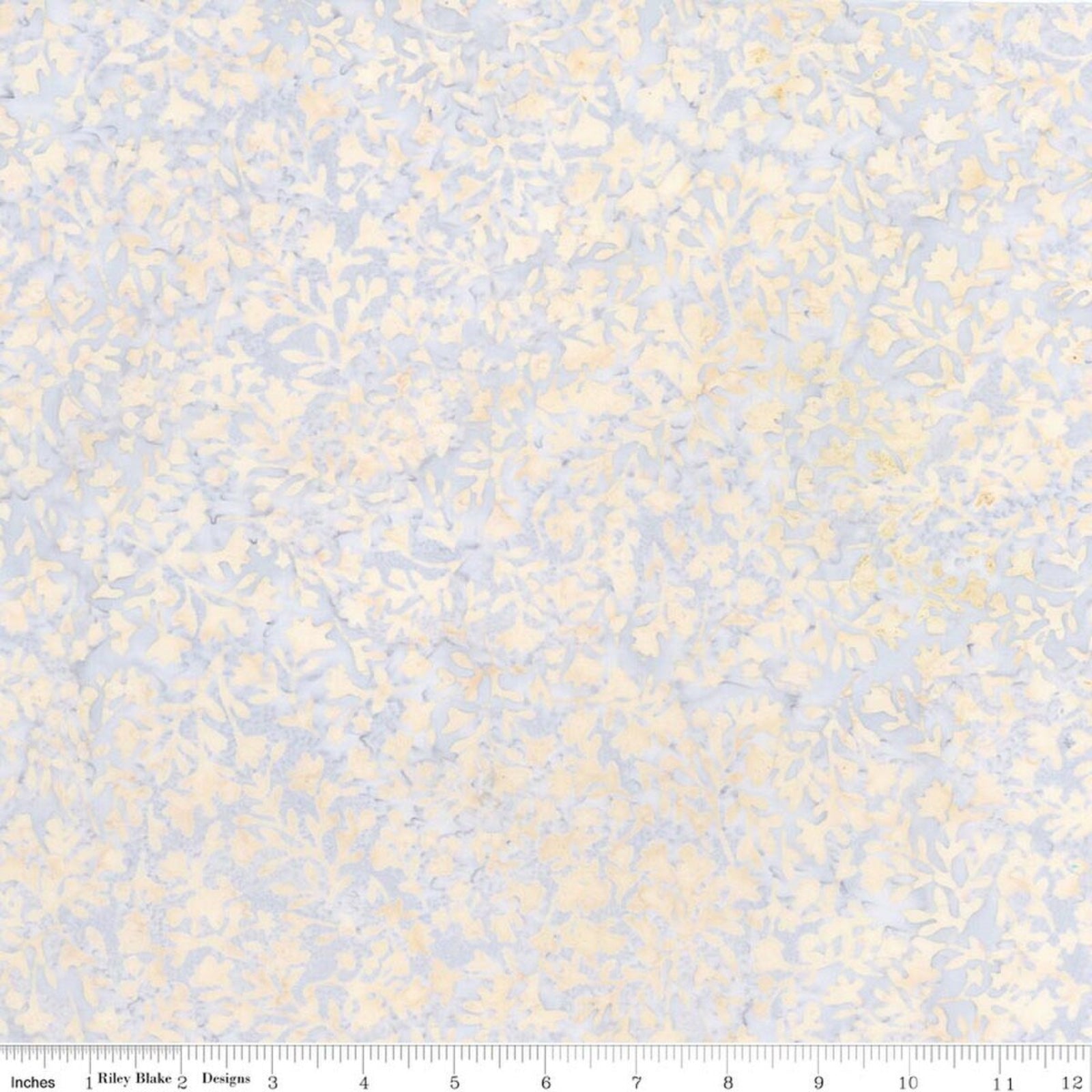 A close-up of a fabric pattern with a light blue and cream floral motif, featuring a ruler scale at the bottom.