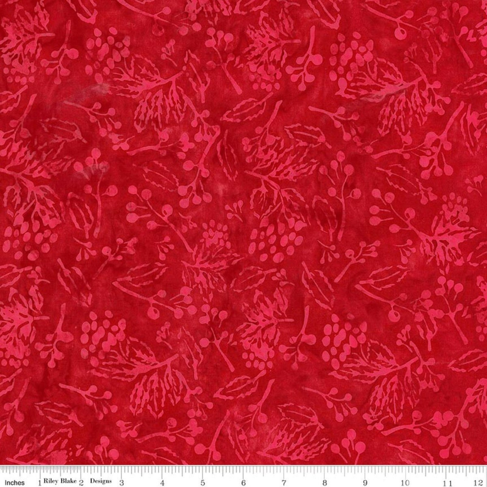 Red batik fabric with a darker red berry and leaf pattern, shown with a 12-inch ruler at the bottom indicating scale.