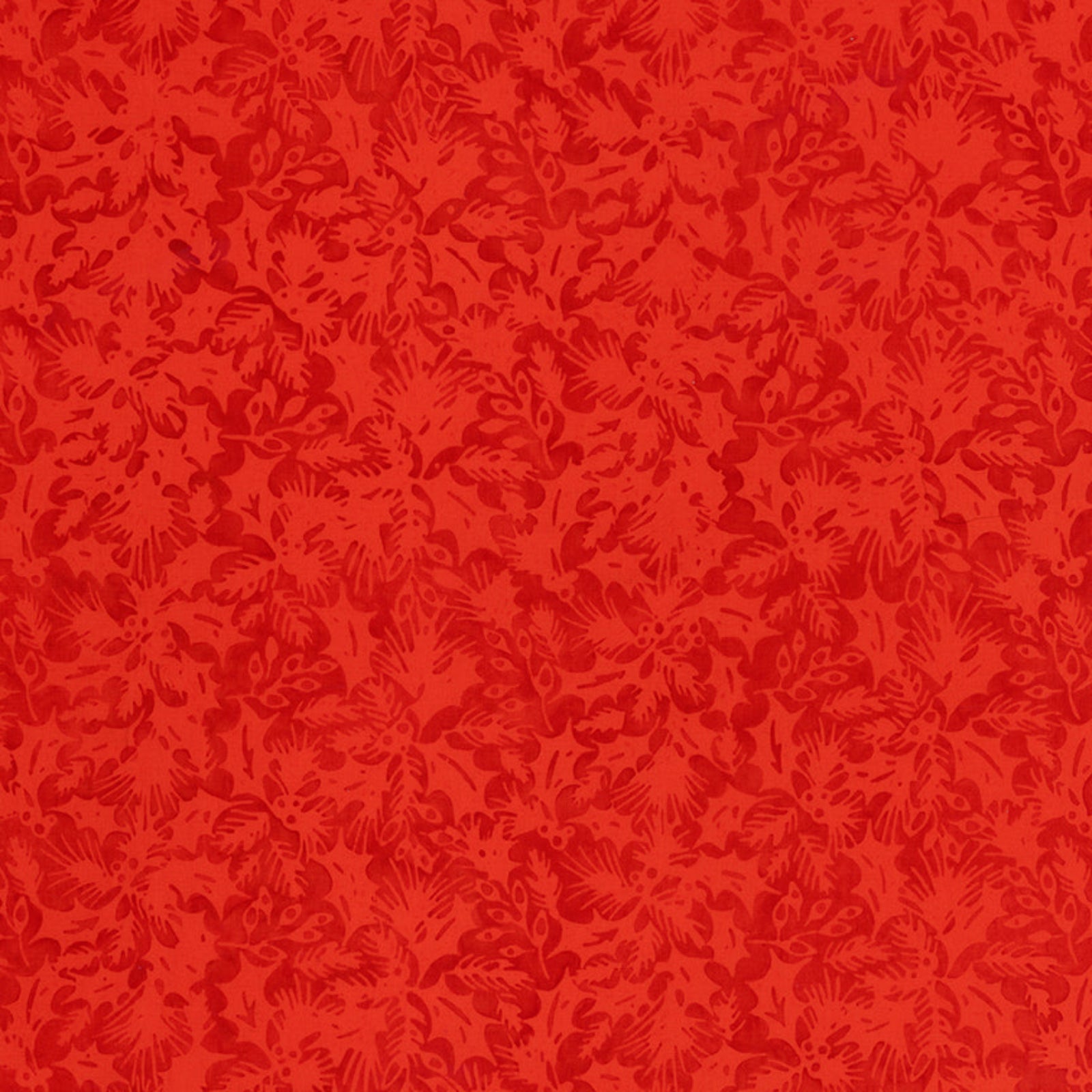 A close-up of a red patterned fabric with an ornate, repeating damask-like floral motif in slightly darker red tones.