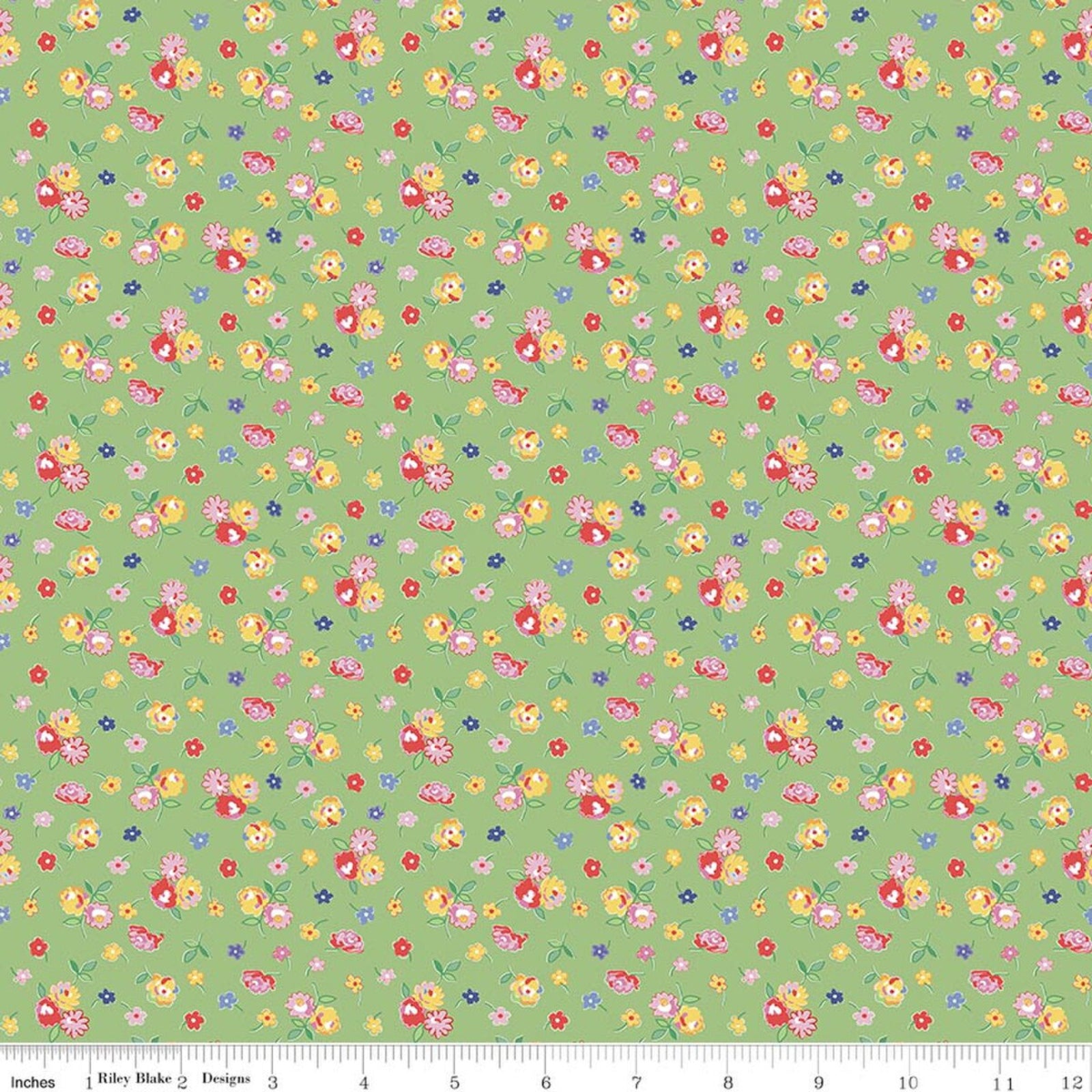 A repeating floral pattern on a light green background with small multicolored flowers and leaves, shown as a fabric or paper swatch with a ruler along the bottom edge.