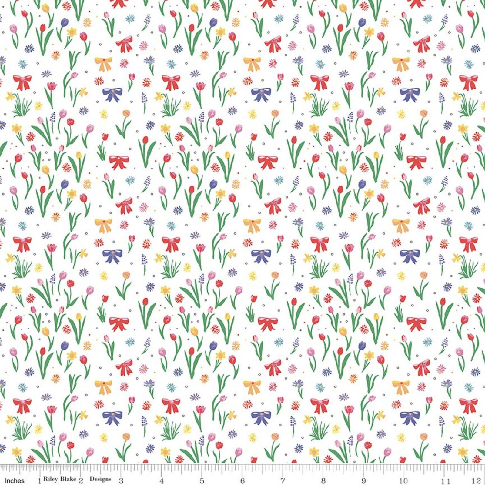 A repeating floral pattern on a white background with small tulips, daisies, wildflowers, and ribbon-bow motifs in red, pink, purple, yellow, and blue. A ruler scale is visible along the bottom edge.