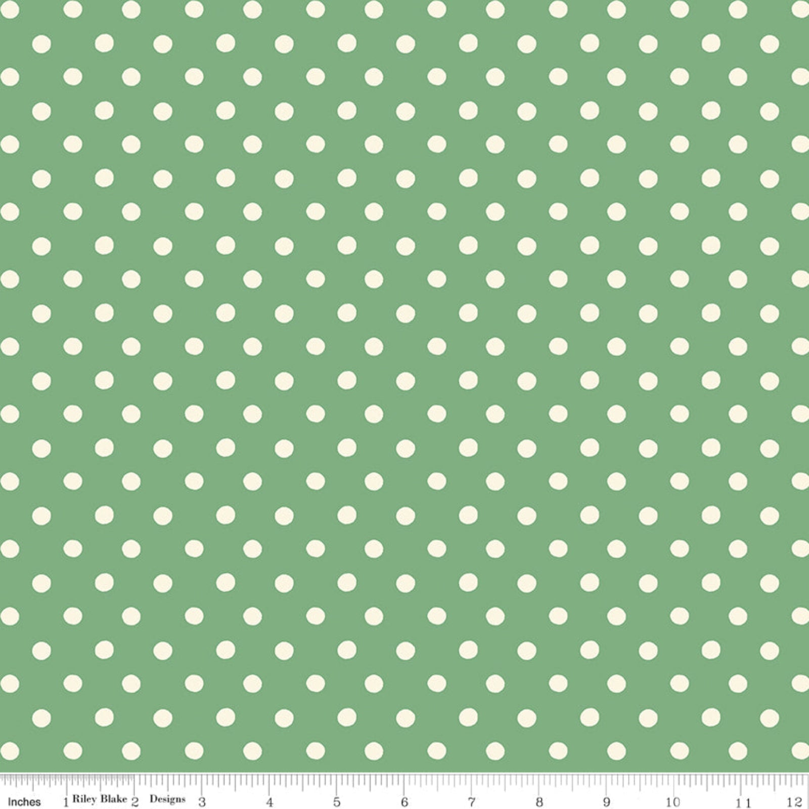 Green fabric with a repeating pattern of white polka dots, shown flat with a ruler along the bottom edge for scale.