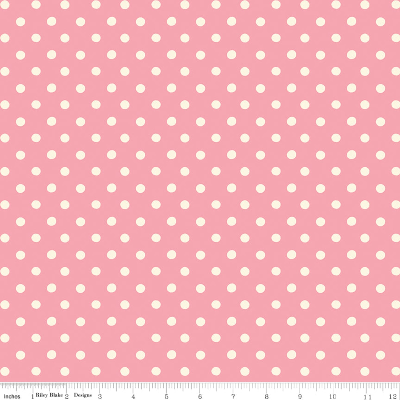 Pink fabric with a repeating pattern of white polka dots, shown flat with a ruler along the bottom edge for scale.