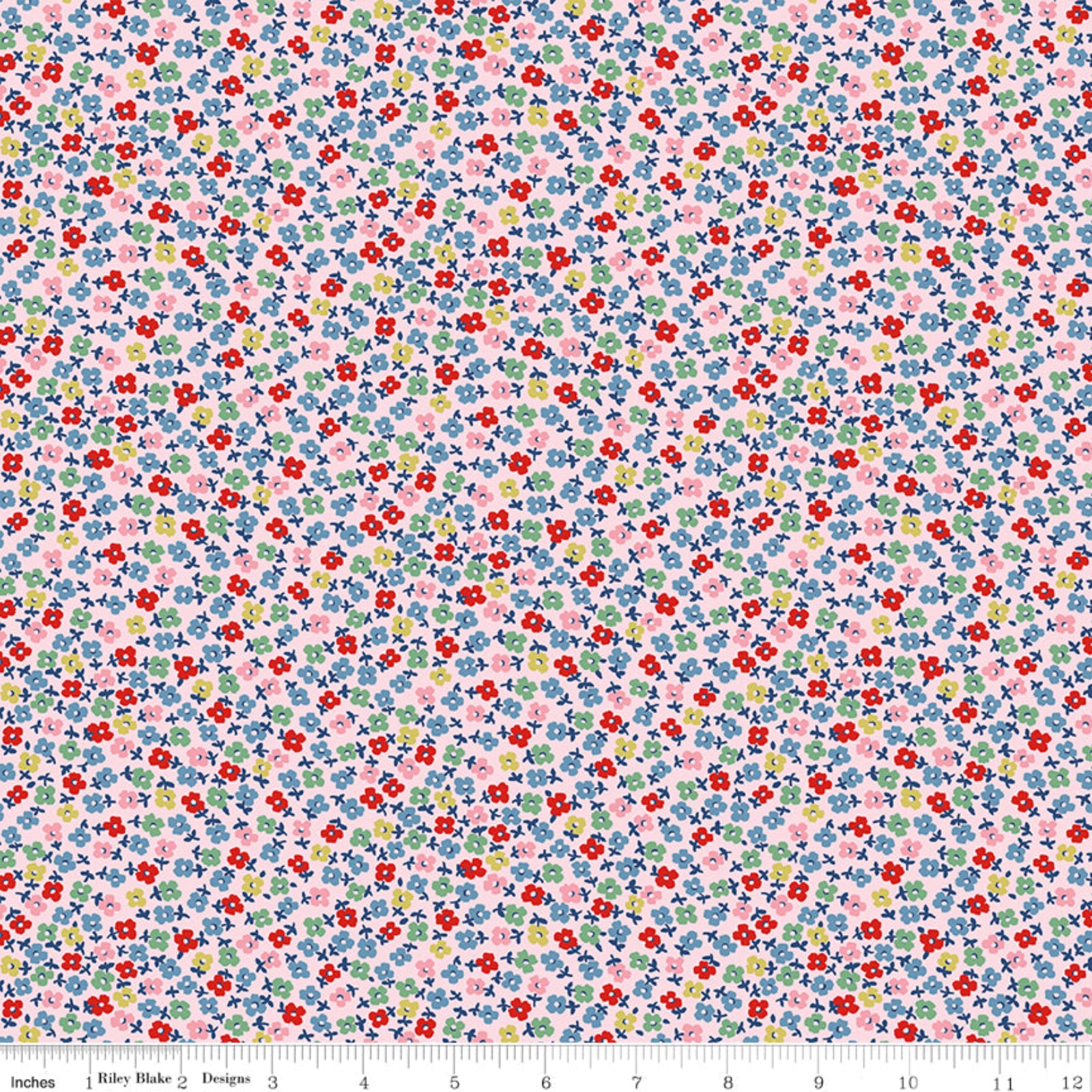 A close-up of a repeating floral fabric pattern with small red, blue, pink, yellow, and green flowers on a pale pink background, with a ruler along the bottom edge showing scale.