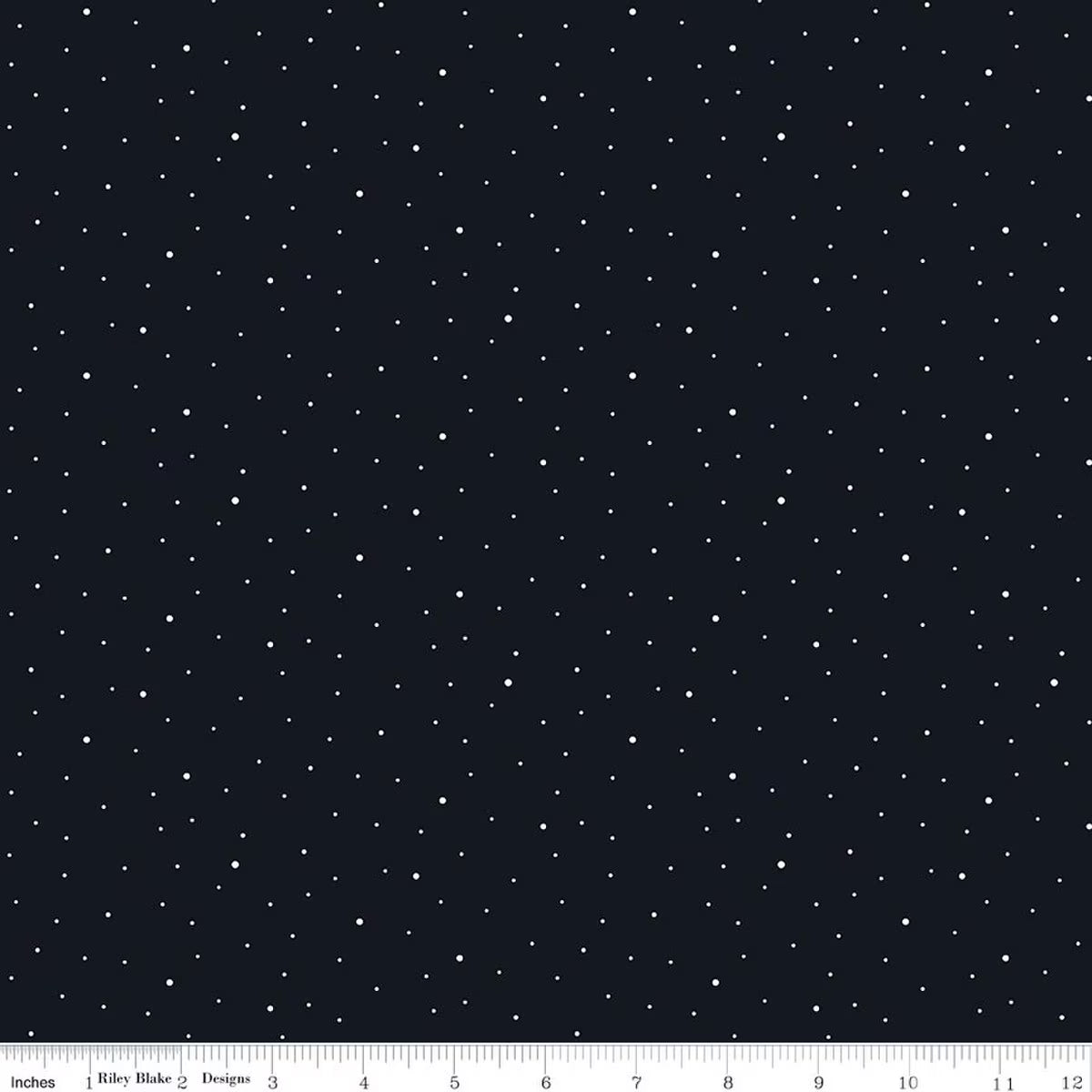 A fabric pattern featuring small white stars scattered across a black background, with a ruler along the bottom edge showing scale.