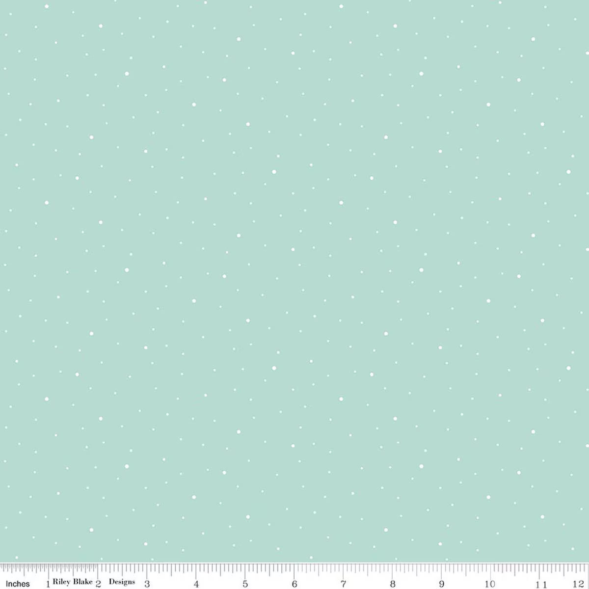 A flat fabric swatch showing a sage green background with a scattered pattern of small white, yellow, and dark green plus-sign motifs. A ruler scale is visible along the bottom edge.