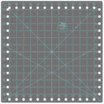 A square gray quilting ruler mat with a light blue grid, measurement markings, and a central circular logo for Creativity Glide.