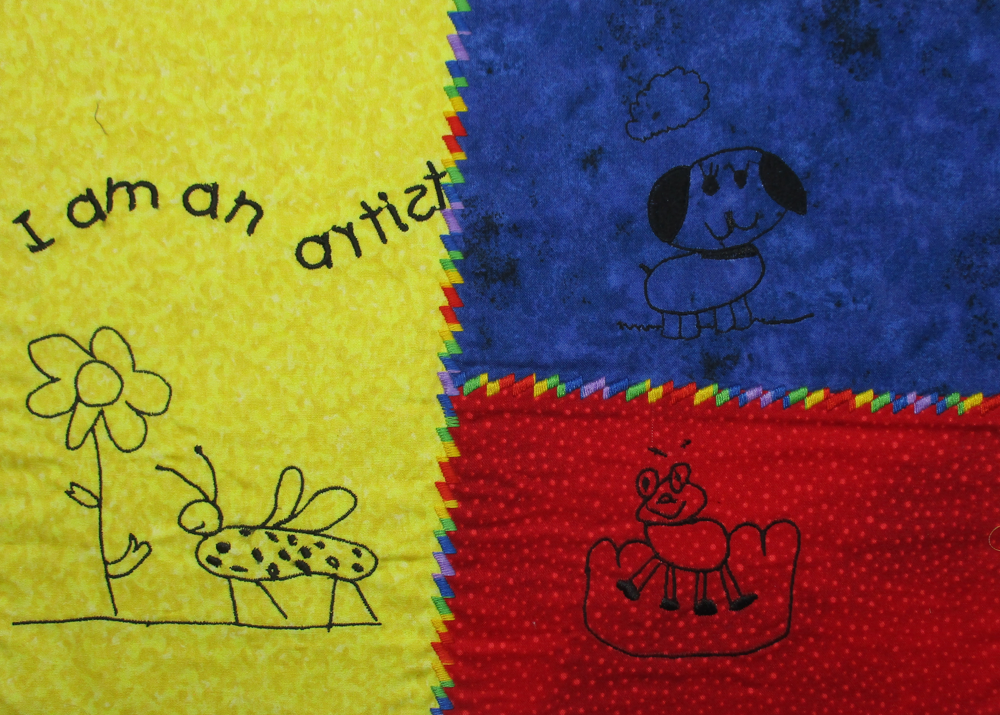 Colorful embroidered designs digitized from a child’s drawings, stitched onto a patchwork fabric panel.