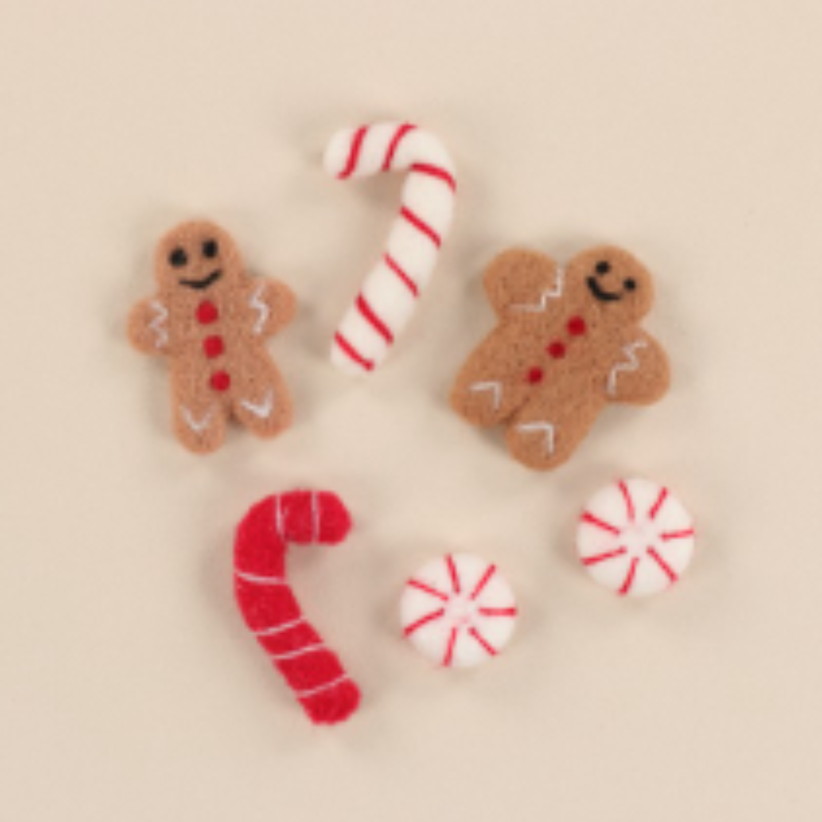 Decorative gingerbread cookies, candy canes, and peppermints on a beige background