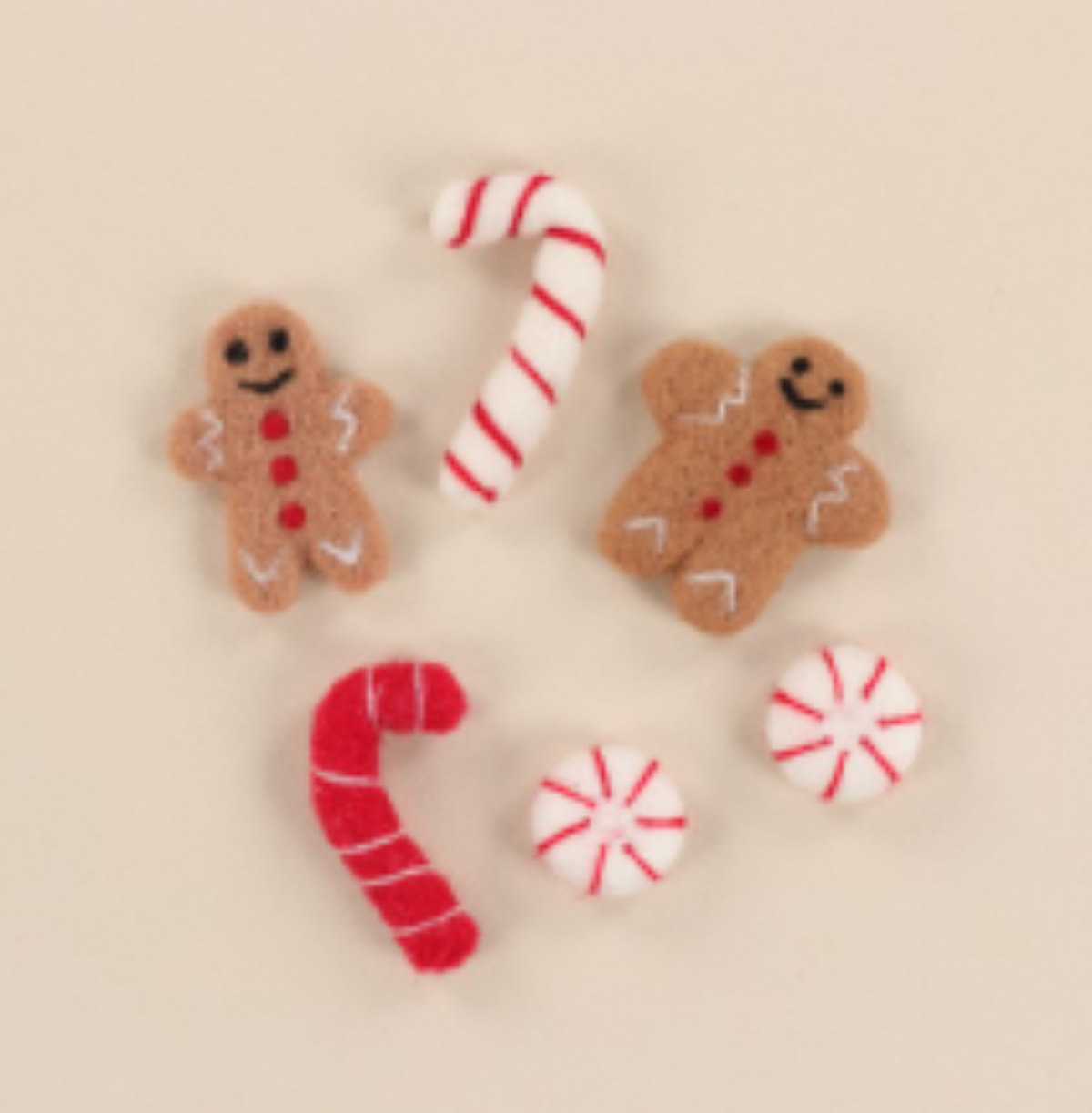 Decorative gingerbread cookies, candy canes, and peppermints on a beige background