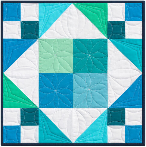 Quilt with geometric pattern in blue, green, and white