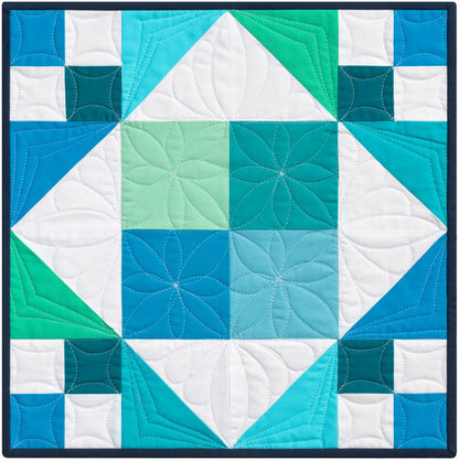 Quilt with geometric pattern in blue, green, and white
