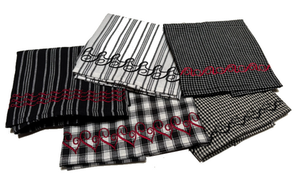 Group of black‑and‑white patterned napkins featuring decorative embroidered borders in red and black thread.