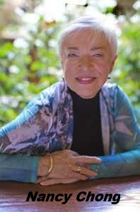 Outdoor portrait of instructor Nancy Chong seated in front of blurred green foliage.