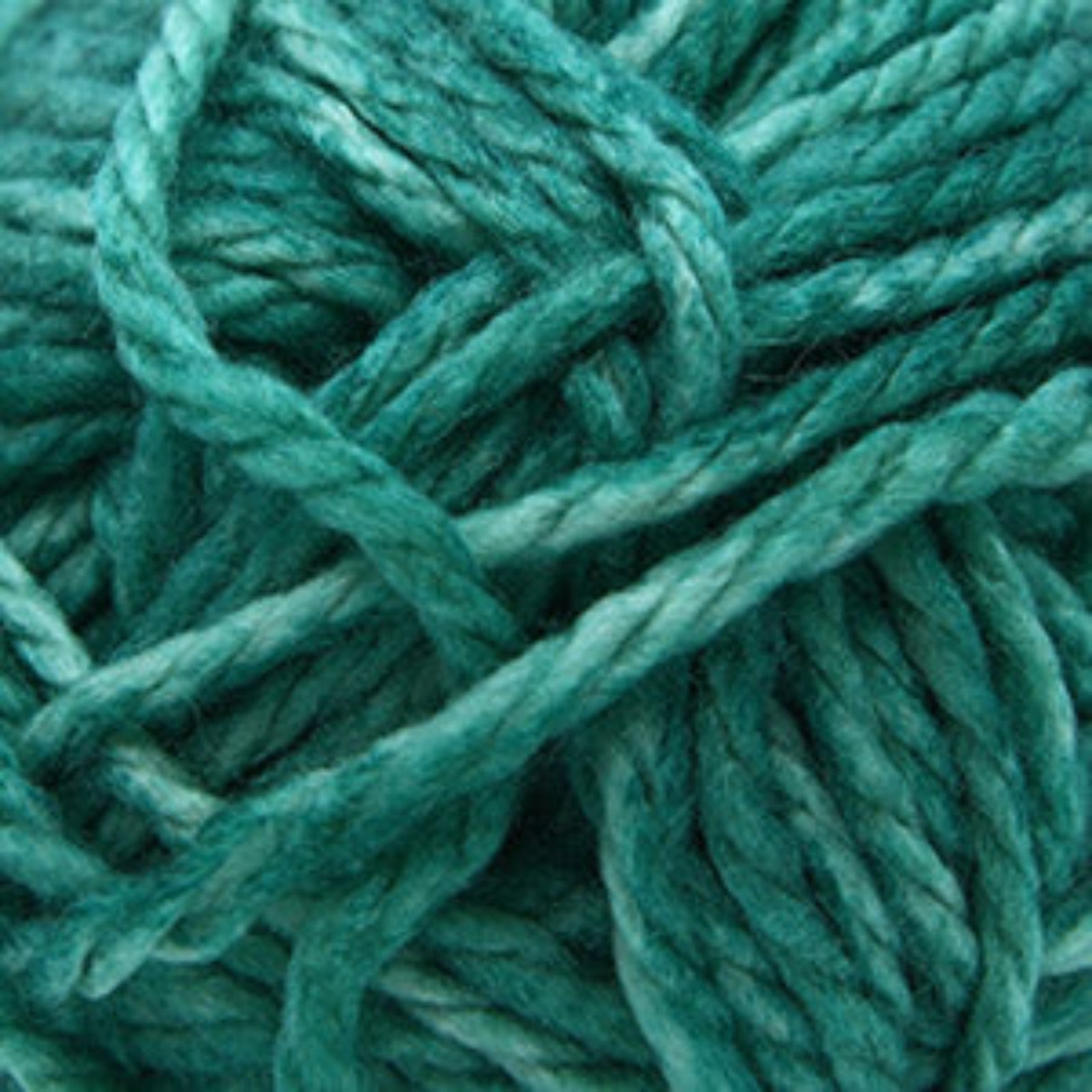 A close-up of teal green yarn strands twisted together, filling the frame.