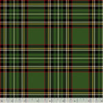 A close-up of a green tartan plaid fabric pattern with black, red, and cream stripes, shown with a white ruler at the bottom edge for scale.