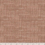 A close-up of a woven fabric texture in a warm dusty rose or mauve-brown tone, with a small ruler strip visible along the bottom edge for scale.