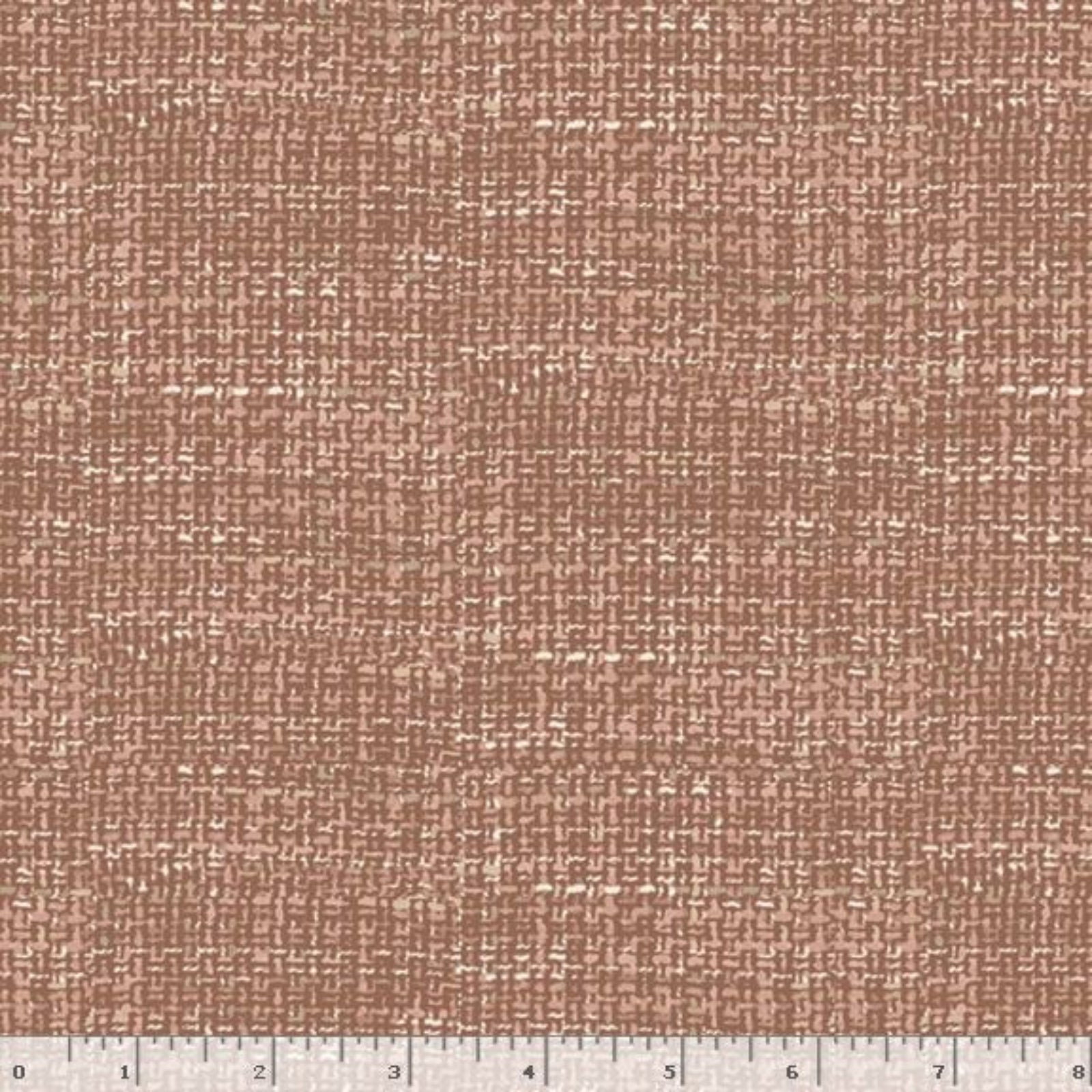 A close-up of a woven fabric texture in a warm dusty rose or mauve-brown tone, with a small ruler strip visible along the bottom edge for scale.