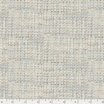 A close-up of a printed woven fabric texture with a small-scale geometric pattern in light beige, cream, and pale blue, with a white ruler at the bottom edge showing scale.