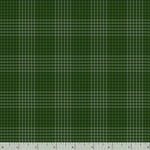 A close-up of a green plaid fabric pattern with a white ruler along the bottom edge showing scale.
