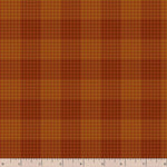A close-up of a fabric pattern showing a warm orange and brown houndstooth plaid texture, with a wooden ruler at the bottom edge showing measurement scale.
