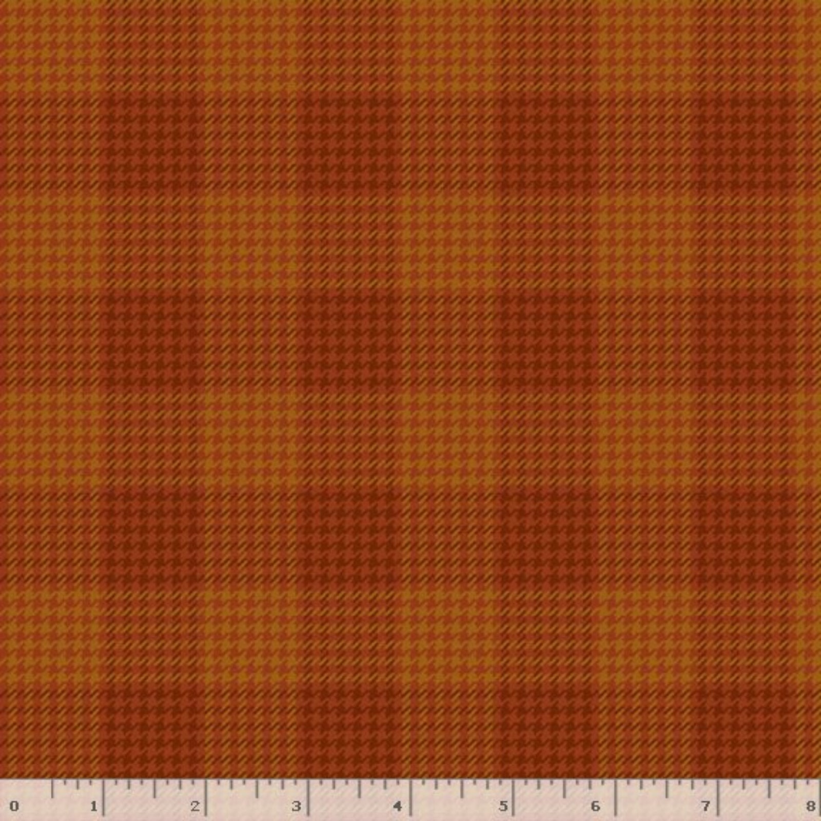 A close-up of a fabric pattern showing a warm orange and brown houndstooth plaid texture, with a wooden ruler at the bottom edge showing measurement scale.