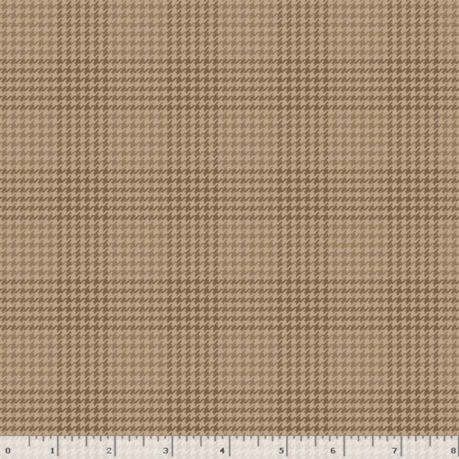 A close-up of a brown and beige houndstooth fabric pattern with a white ruler at the bottom edge showing scale.