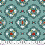 A repeating fabric pattern featuring intricate floral and geometric medallion motifs in teal, white, rust red, and dark green, with a white fabric ruler visible along the bottom edge.