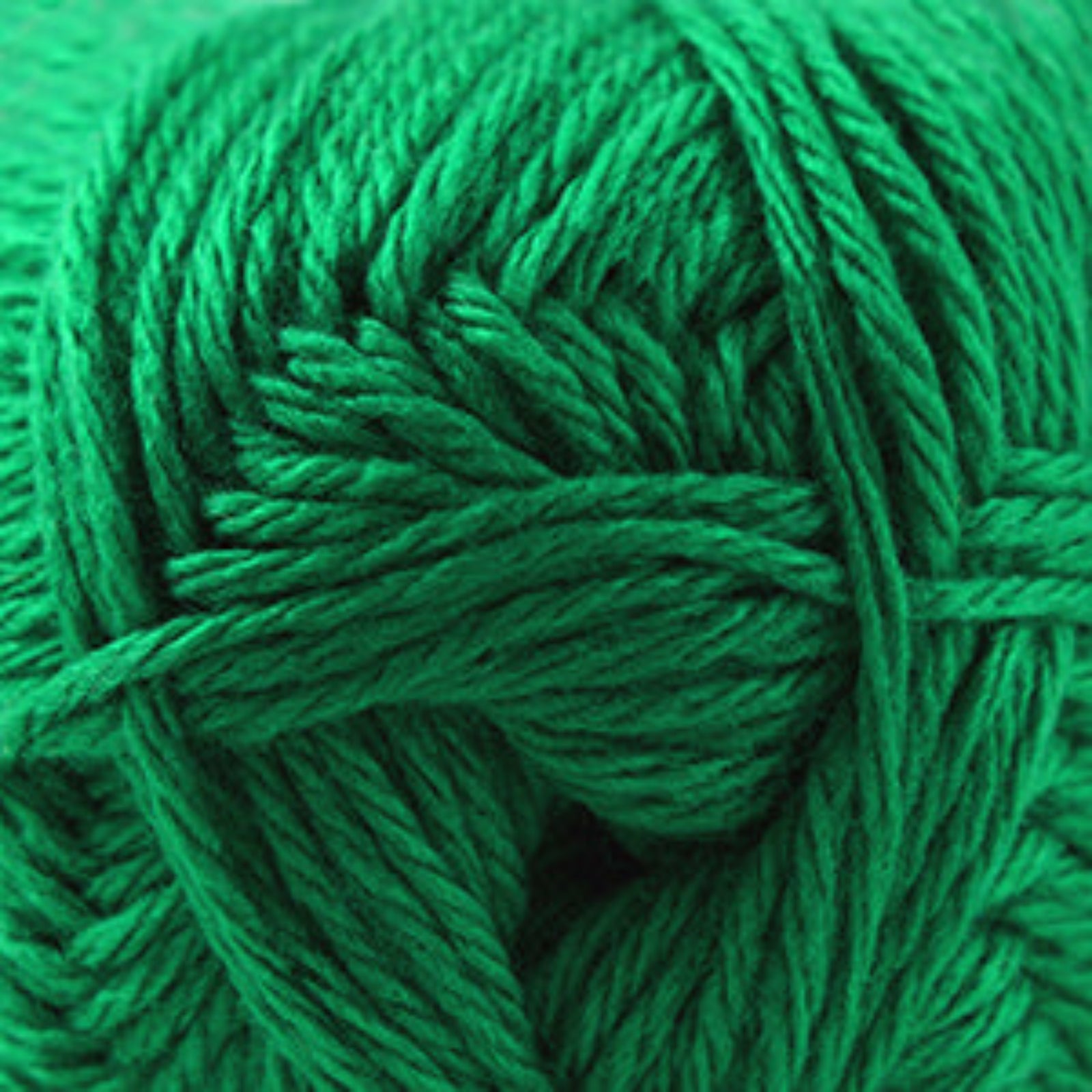 A close-up of bright green yarn wound into a skein, filling the frame.