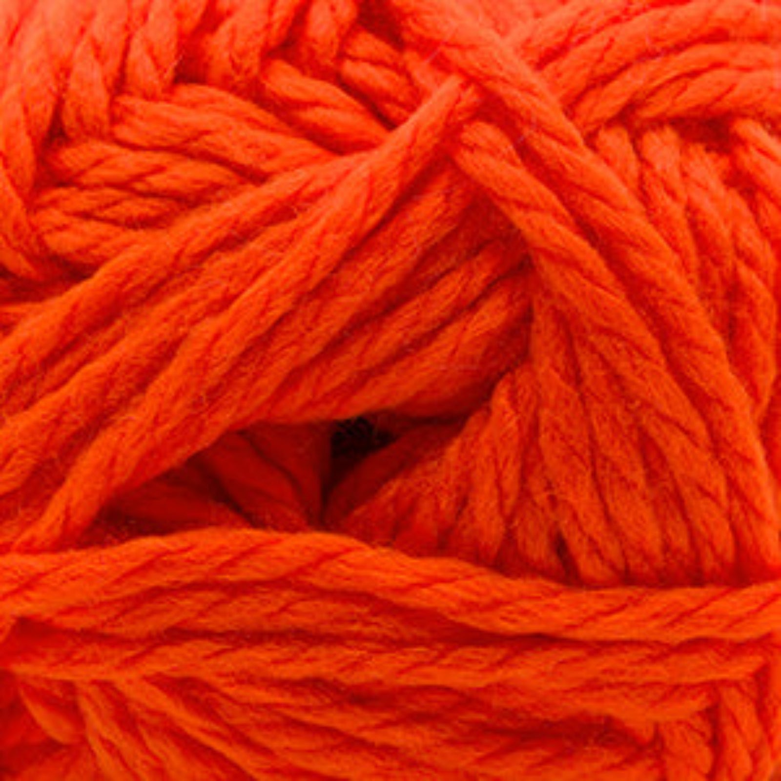 A close-up of bright orange yarn strands twisted into a ball, filling the entire frame.