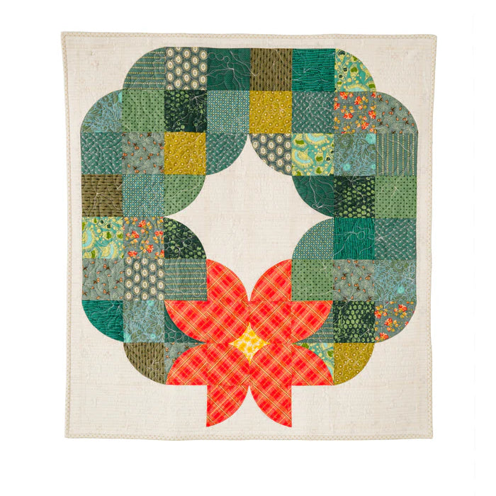 Posh Wreath quilt in bright green fabrics with layered curved blocks displayed on a dark wall.