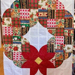 Posh Wreath quilt block made with festive holiday prints and a red poinsettia center before quilting.