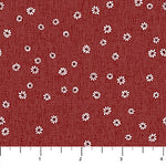 Red fabric with a white daisy pattern and a ruler scale at the bottom.