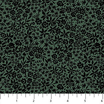A close-up of a fabric pattern featuring black floral and leafy motifs on a muted sage green background, with a white ruler at the bottom showing scale.
