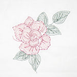 Pink and green embroidered flower design on white fabric, used to demonstrate reduced‑density stitching.