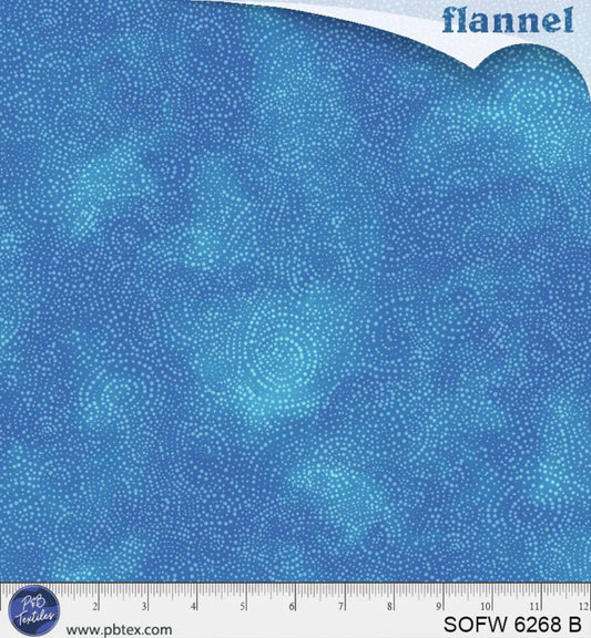 Blue flannel fabric with circular patterns and a ruler at the bottom for scale.