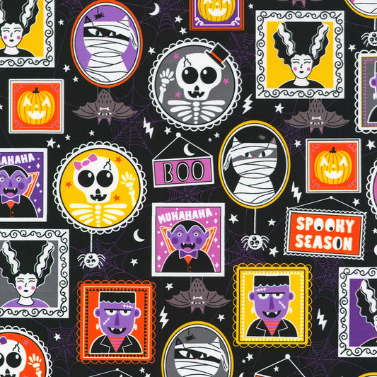 Halloween-themed fabric with various spooky characters and text on a black background.