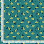 Patterned fabric with cartoon characters on a teal background, measured by a ruler.