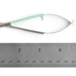 A pair of small metal snips with a mint green handle, shown above a metal ruler to indicate scale on a white background.