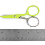Bright lime green and stainless steel scissors positioned above a metal ruler on a white background.